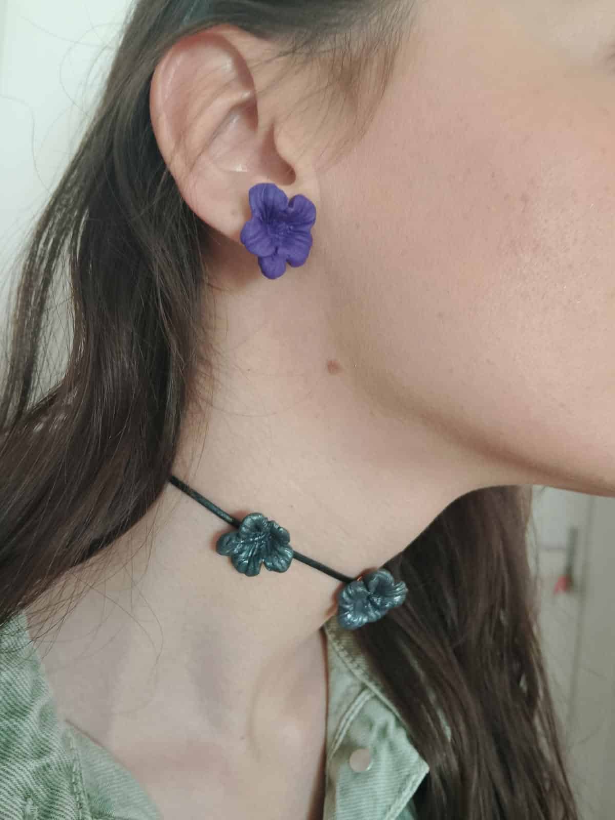 boucle d'oreille en forme de fleur violette portée