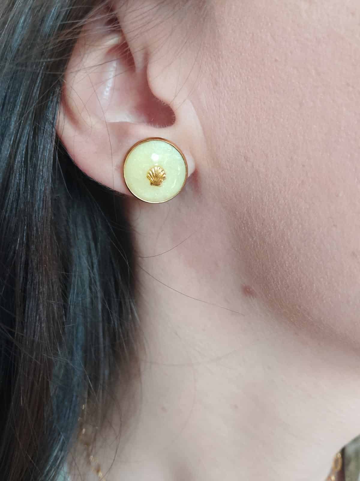 boucle d'oreille ronde vert pâle portée à l'oreille